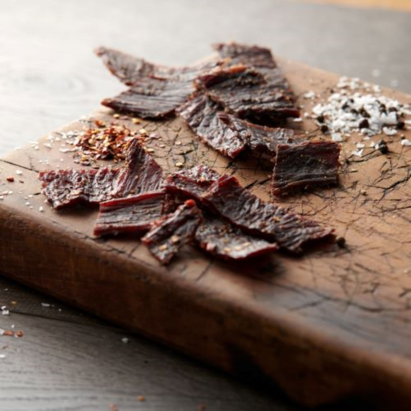 all natural beef jerky on cutting board with seasoning