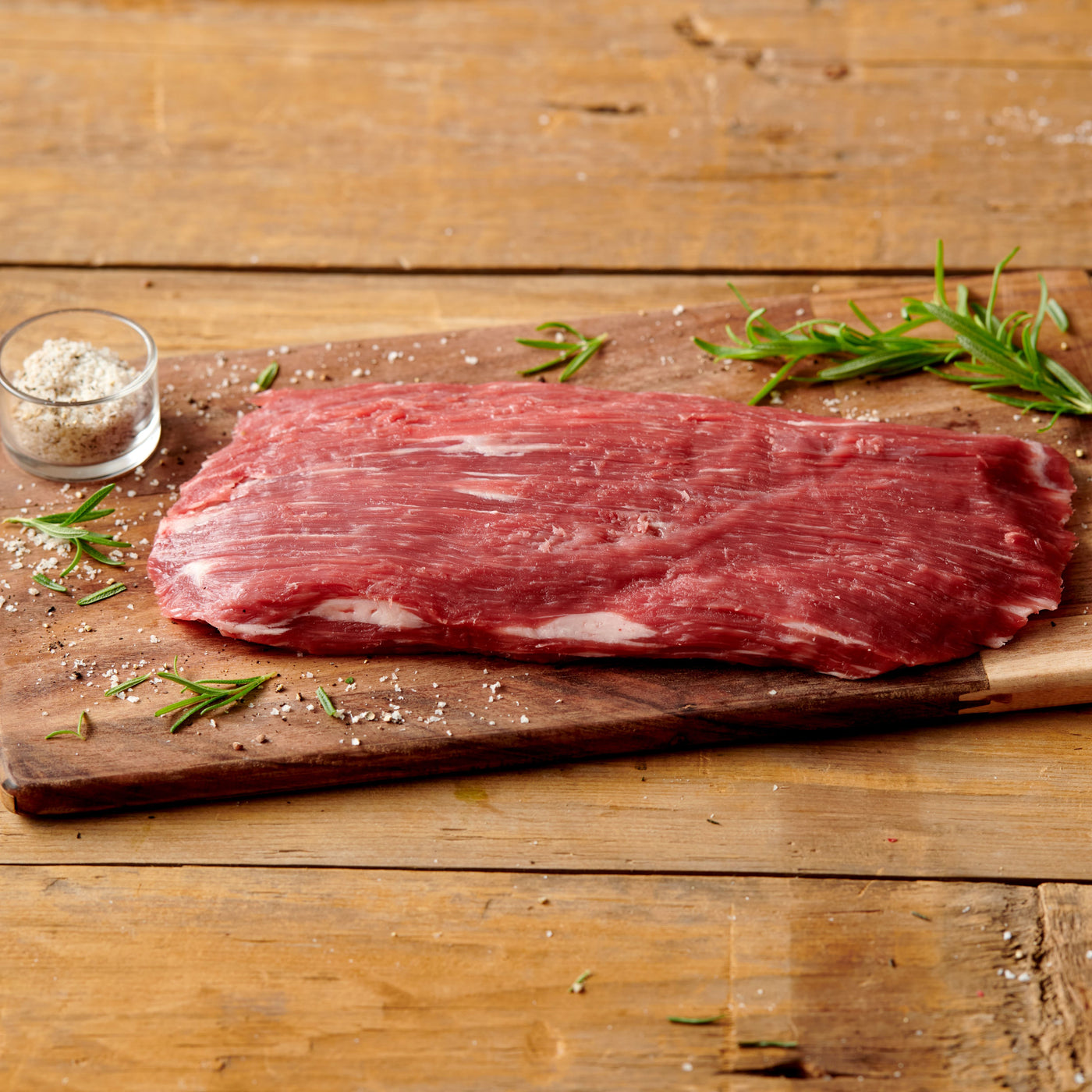 usda choice angus beef flank steak on wooden cutting board