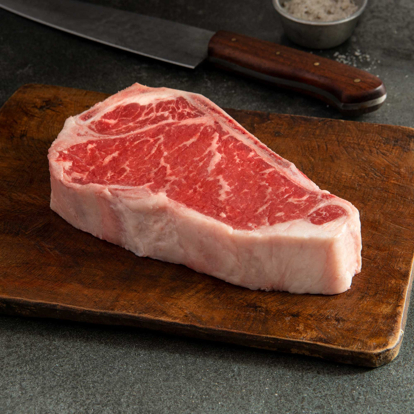 USDA Choice Black Angus Bone-In New York Strip Steak (Kansas City Strip) from 44 Farms with rich marbling and a premium bone-in steakhouse presentation